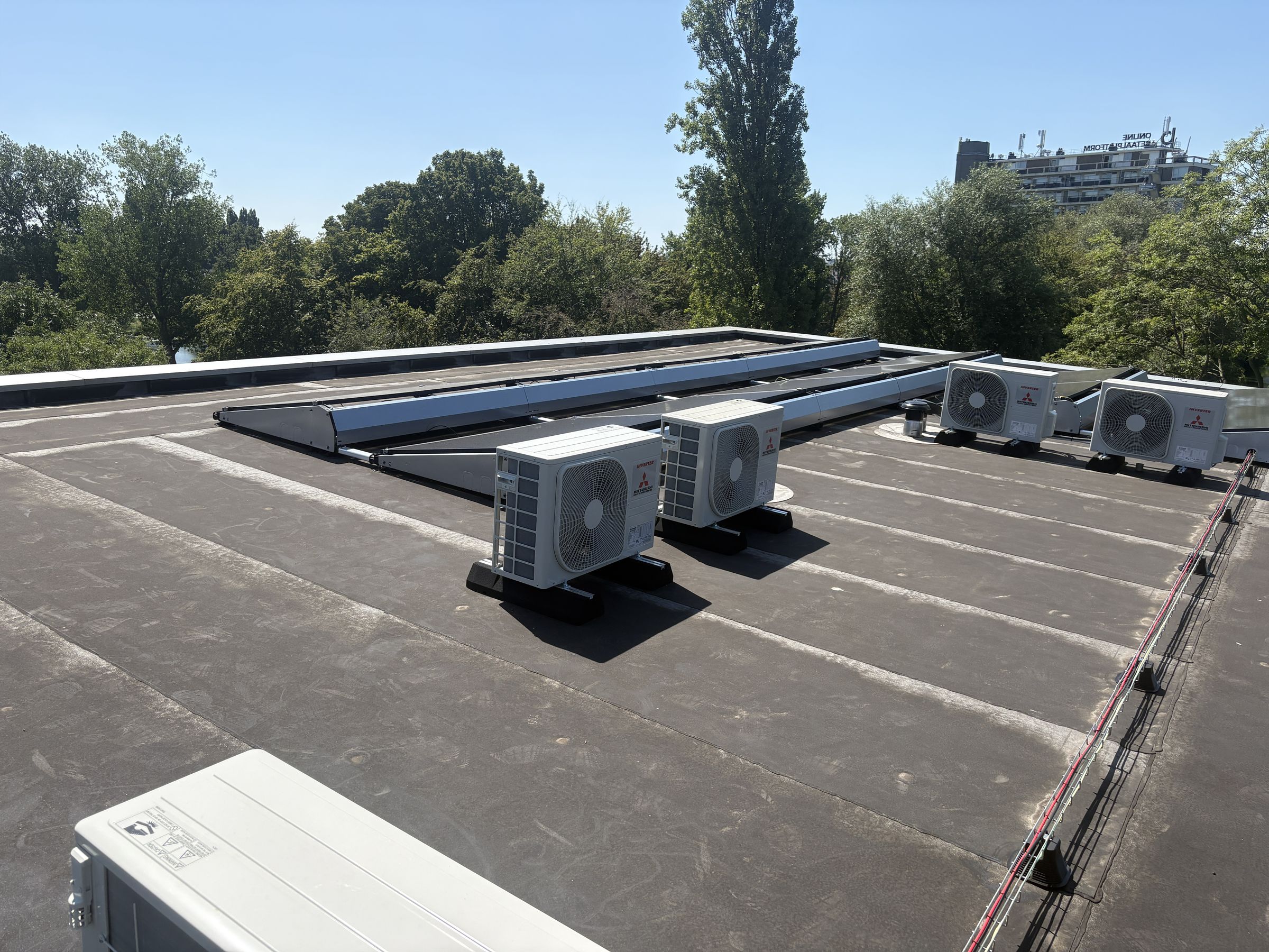 Mitsubishi airco-buitenunits op het platte dak van een bedrijfspand, geplaatst door Kemp