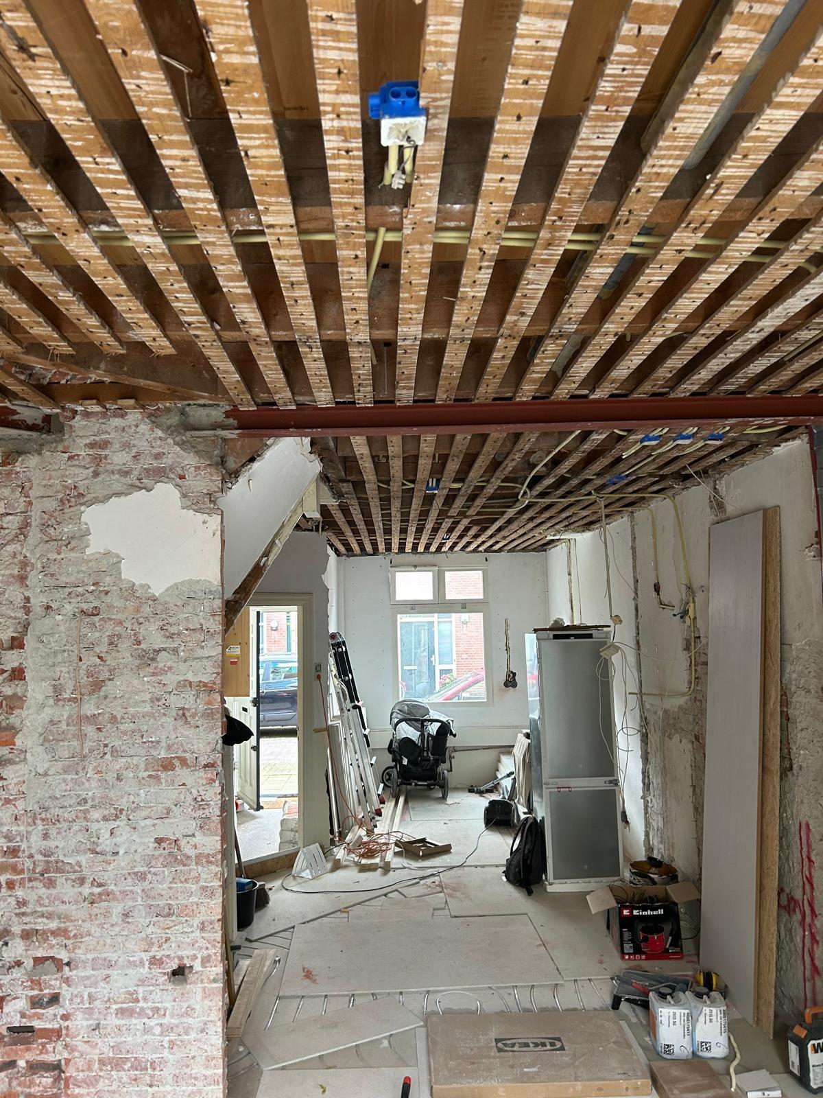 Renovatie met open plafond: nieuwe installatiebuis en inbouwdozen tussen de balken